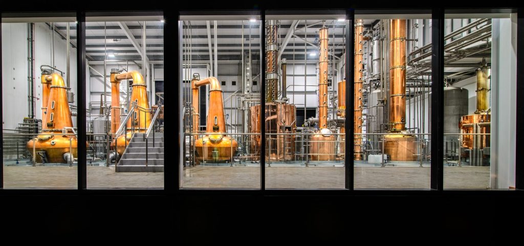 The West Cork Distillery still house lit up at night